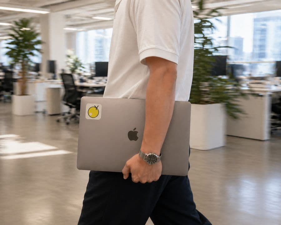 A rep walking through the office, laptop with a Yuzu sticker under one arm